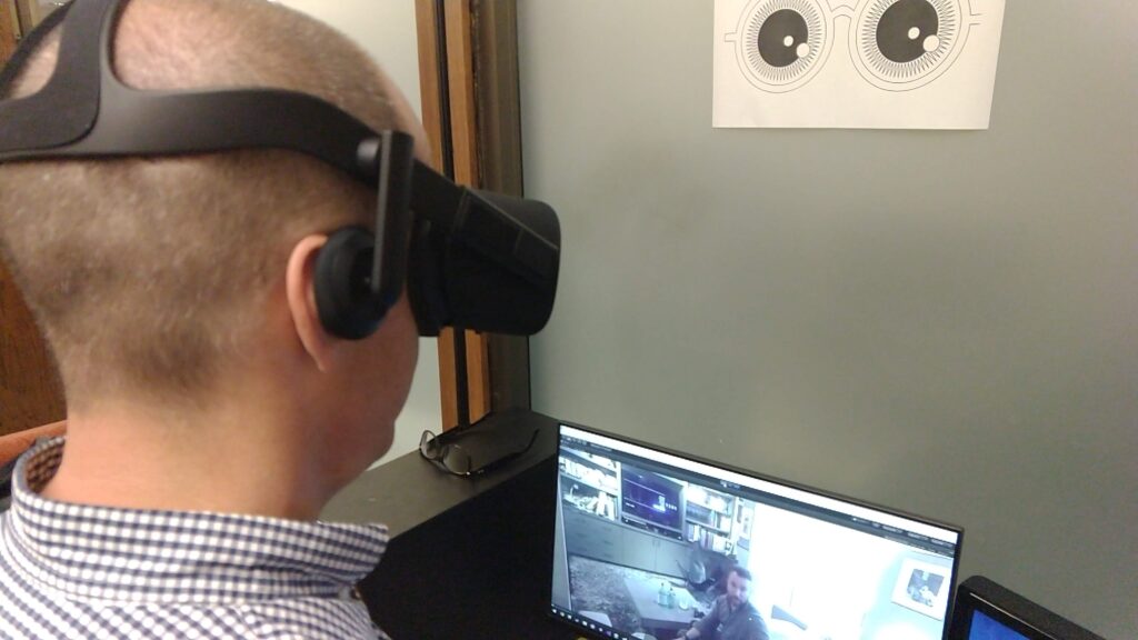 man wearing VR goggles at his work desk.
